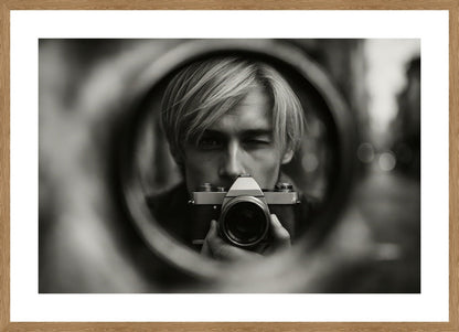 Through The Lens affisch stylad i interiörmiljö med ekram.