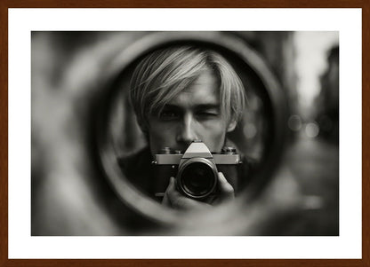 Through The Lens affisch stylad i interiörmiljö med mörk ekram.